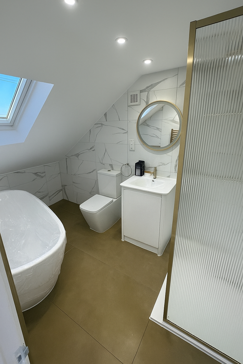 Loft-conversion bathroom with marble tiling, freestanding bath and round mirror