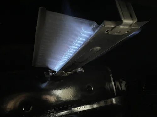 Boiler burner showing a clean blue flame during gas service